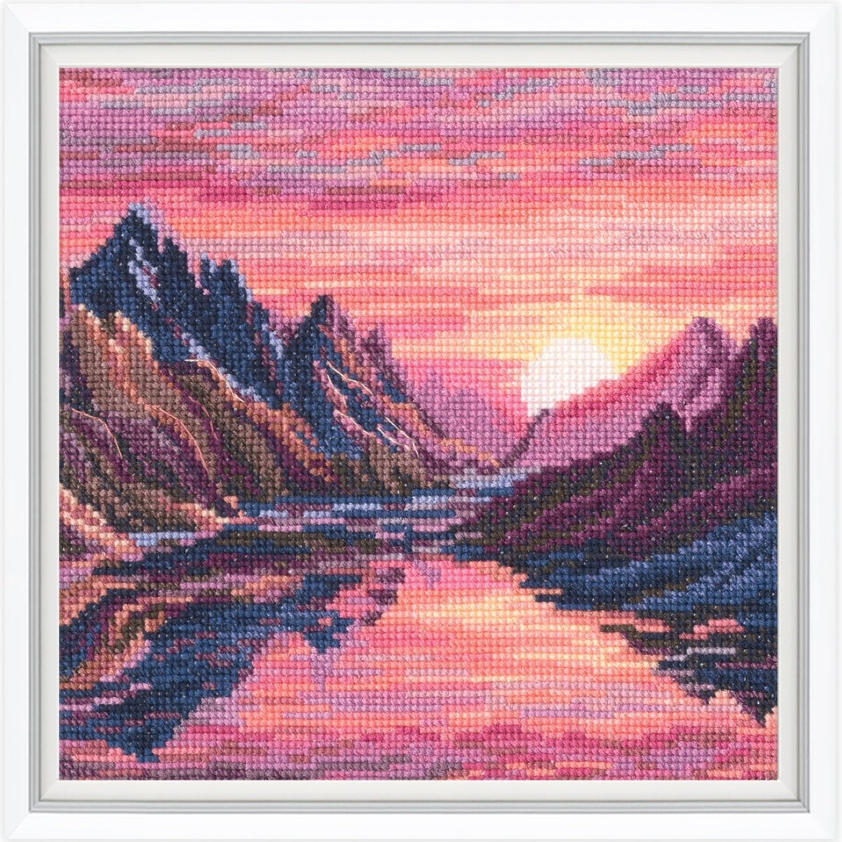 Cross-stitched landscape of mountains and a lake with a pink sky.